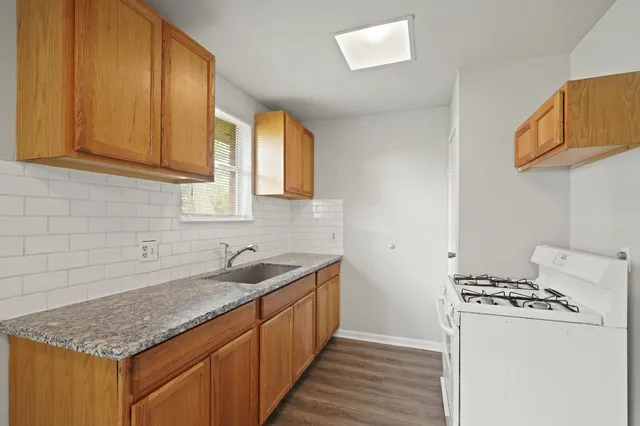 a kitchen with stainless steel appliances granite countertop a sink stove and refrigerator