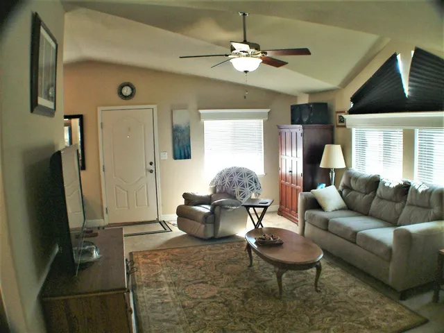 a living room with furniture a table and a large window