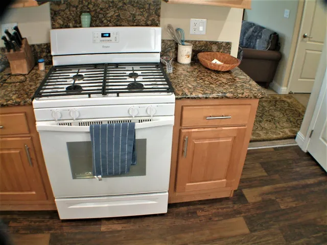 a kitchen with granite countertop white cabinets and white appliances