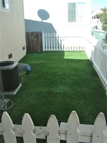 a backyard of a house with table and chairs