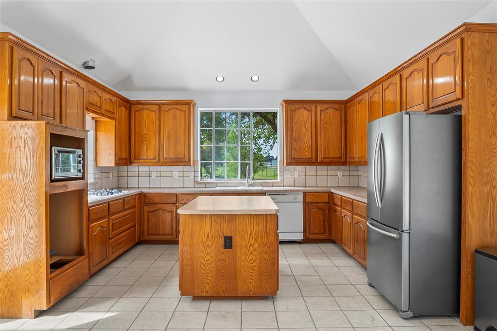 1082 Post Oak Road Copper Canyon, TX 76226 - Photo 11 of 40 a kitchen with stainless steel appliances granite countertop a refrigerator a stove top oven and sink