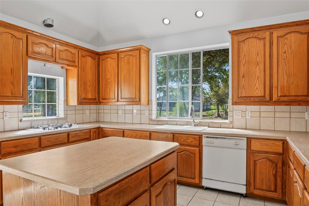 1082 Post Oak Road Copper Canyon, TX 76226 - Photo 12 of 40 a kitchen that has a sink and a table in it