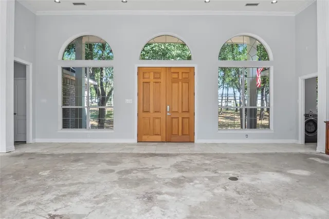 a view of an empty room with a fireplace and a window