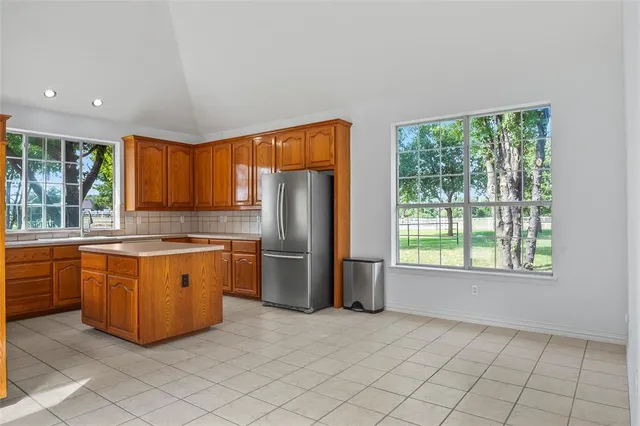 a kitchen with stainless steel appliances granite countertop a refrigerator a stove top oven and sink