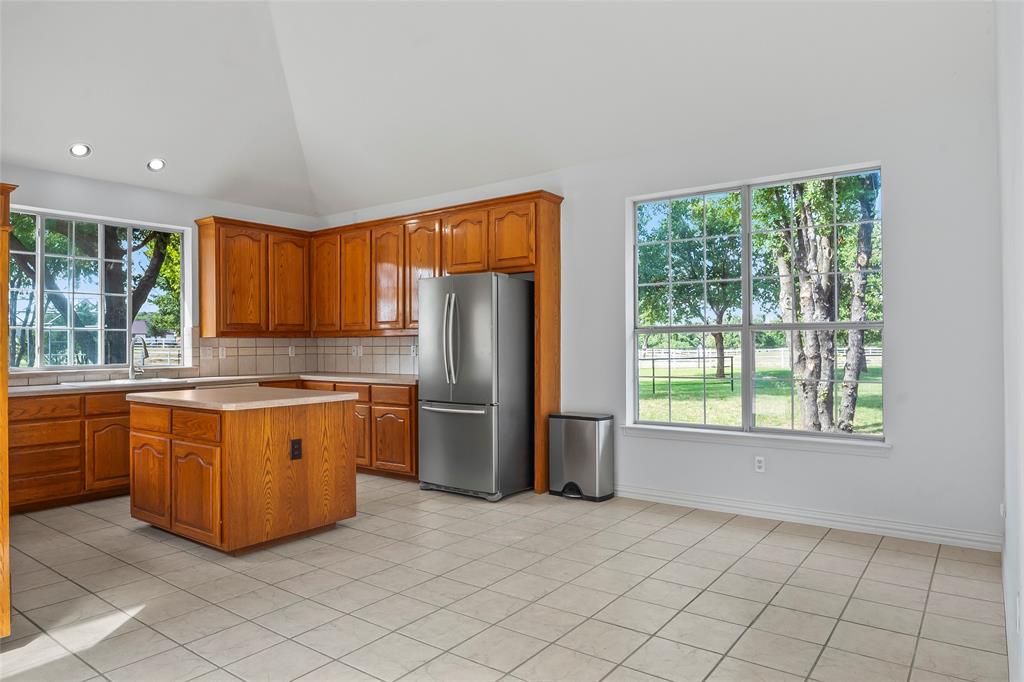 1082 Post Oak Road Copper Canyon, TX 76226 - Photo 10 of 40 a large kitchen with stainless steel appliances granite countertop a refrigerator a sink a stove a washer and dryer with wooden floor
