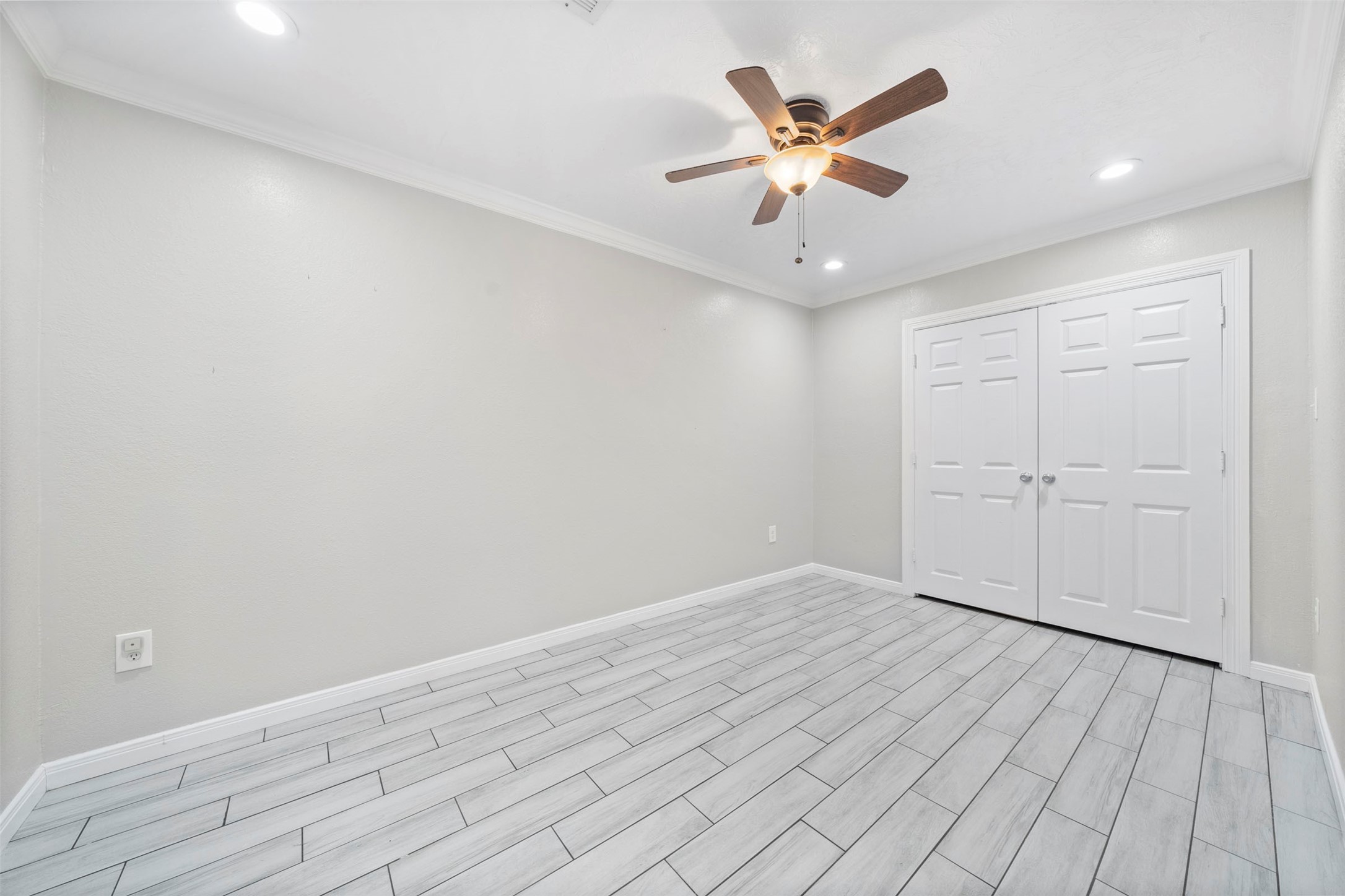7941 Goode Street Houston, TX 77012 - Photo 13 of 26 an empty room with wooden floor and ceiling fan