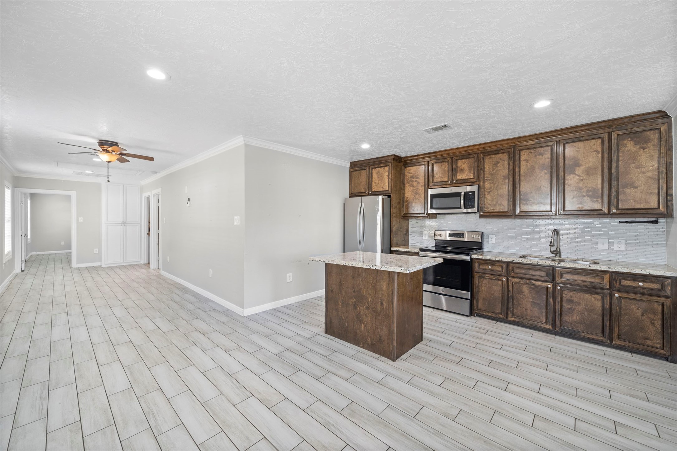 7941 Goode Street Houston, TX 77012 - Photo 19 of 26 a kitchen with stainless steel appliances granite countertop a stove top oven a sink dishwasher a refrigerator and cabinets with wooden floor