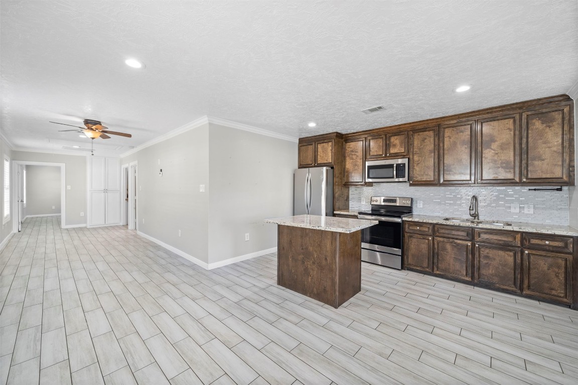 7941 Goode Street Houston, TX 77012 - Photo 19 of 26 a kitchen with stainless steel appliances granite countertop a stove top oven a sink dishwasher a refrigerator and cabinets with wooden floor