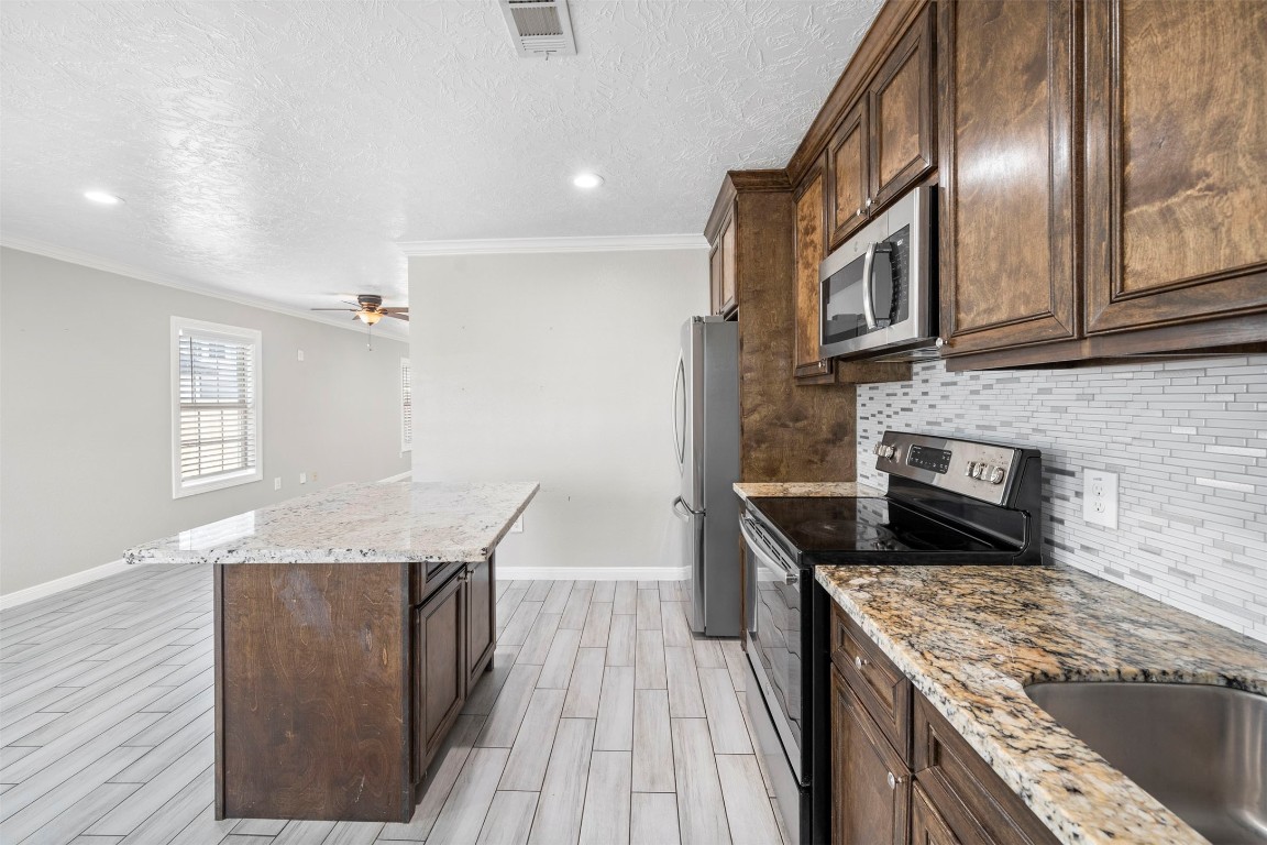7941 Goode Street Houston, TX 77012 - Photo 21 of 26 a kitchen with granite countertop cabinets stainless steel appliances and a counter space