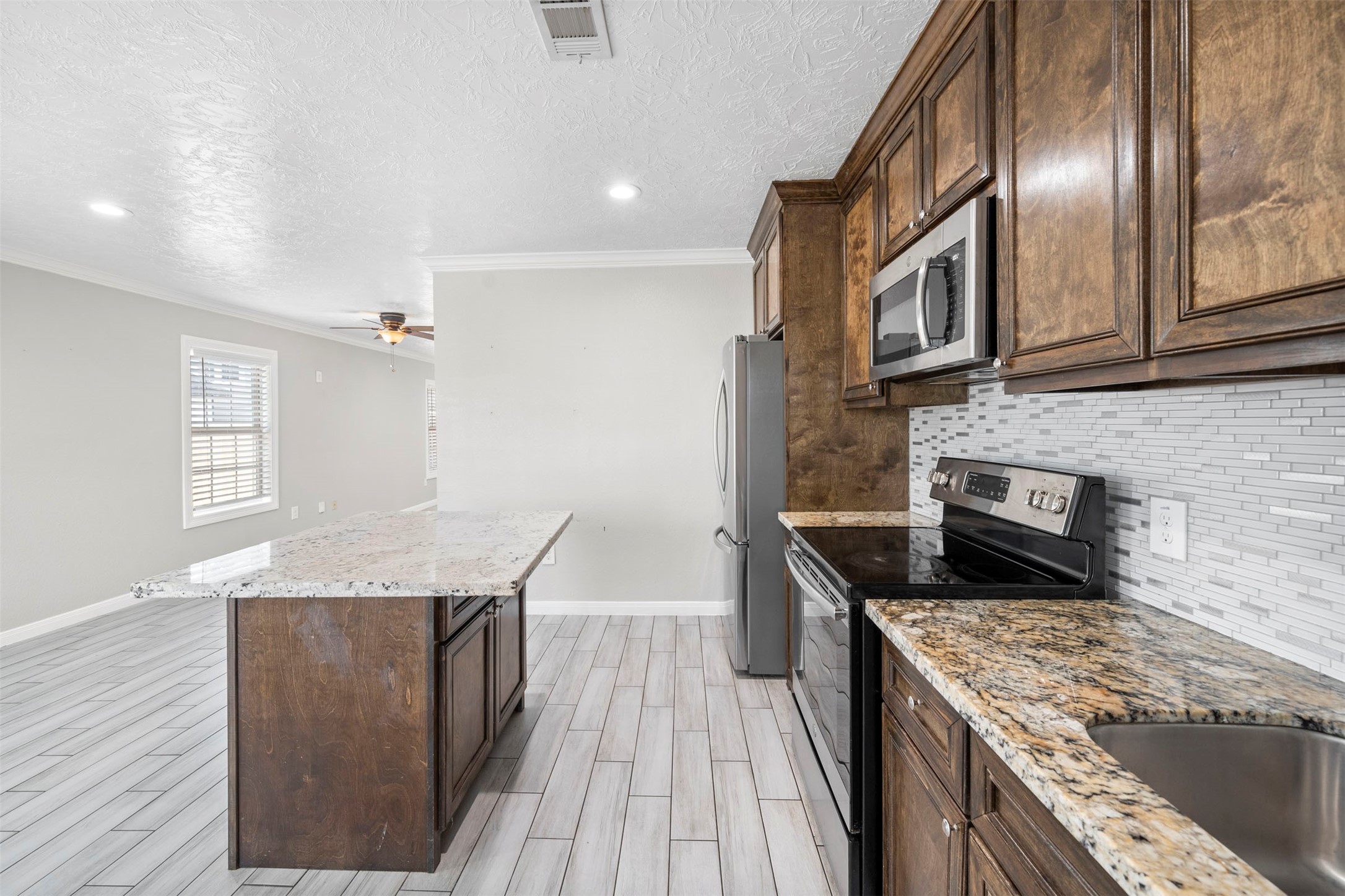 7941 Goode Street Houston, TX 77012 - Photo 21 of 26 a kitchen with granite countertop cabinets stainless steel appliances and a counter space
