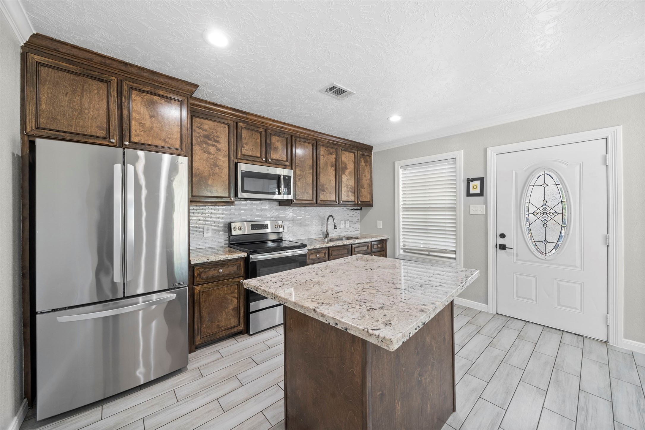 7941 Goode Street Houston, TX 77012 - Photo 22 of 26 a kitchen with granite countertop stainless steel appliances and wooden cabinets