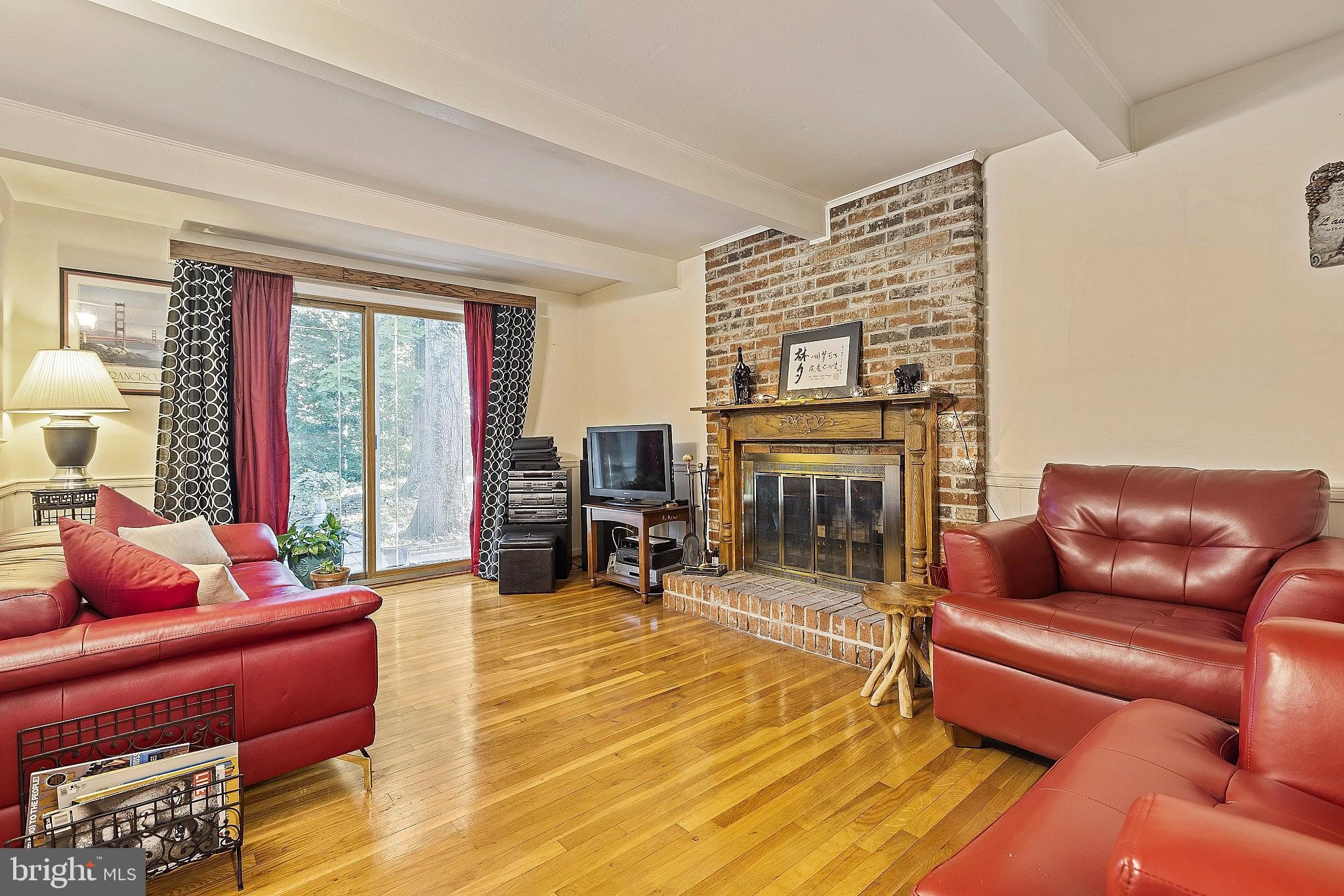 5210 Windmill Lane Columbia, MD 21044 - Photo 2 of 29 a living room with furniture a fireplace and a floor to ceiling window
