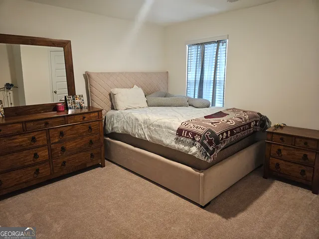 a spacious bedroom with a bed and a dresser