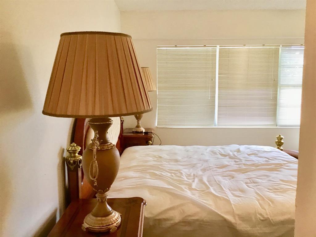 204 Preston Way, Unit 204 Boca Raton, FL 33434 - Photo 17 of 31 a bed sitting in a bedroom next to a window