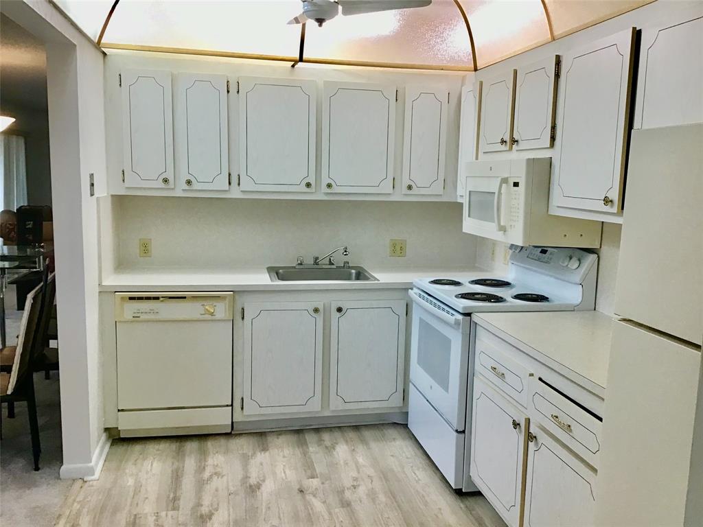 204 Preston Way, Unit 204 Boca Raton, FL 33434 - Photo 3 of 31 a kitchen with white cabinets and white appliances