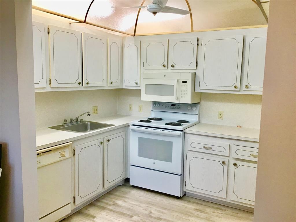 204 Preston Way, Unit 204 Boca Raton, FL 33434 - Photo 4 of 31 a kitchen with white cabinets and white appliances