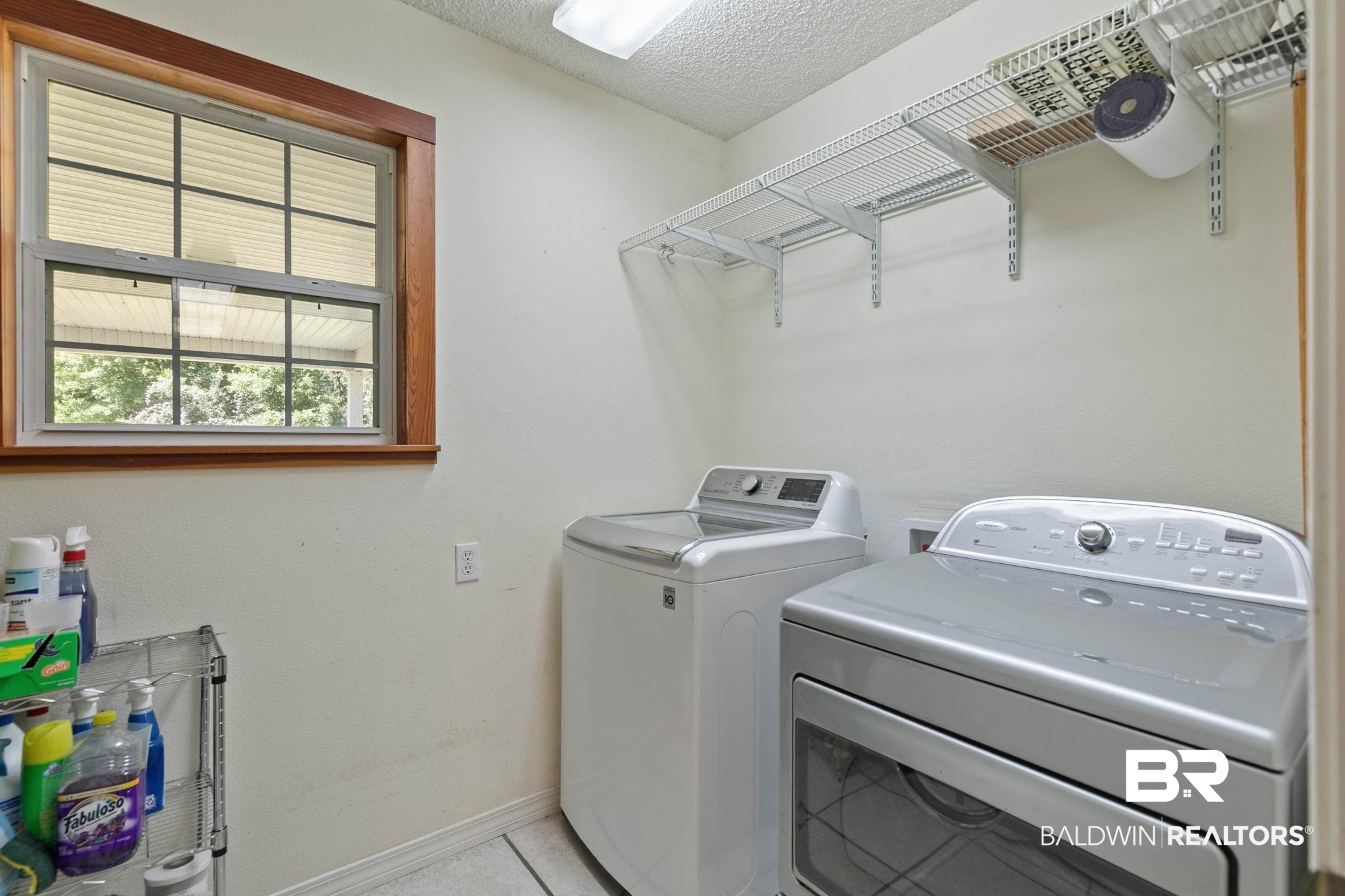 20219 Greek Cemetery Road Robertsdale, AL 36567 - Photo 20 of 41 Laundry room featuring a window with wood-finish trim, white walls, and overhead wire shelving