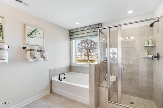 a bathroom with a double vanity sink a mirror and a bathtub