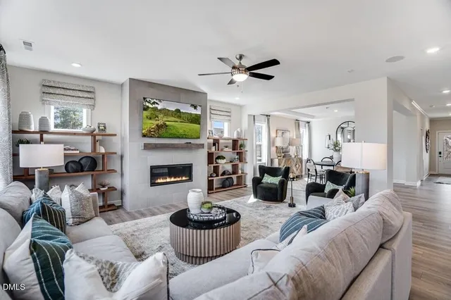 a kitchen with stainless steel appliances kitchen island granite countertop a dining table chairs stove refrigerator and cabinets