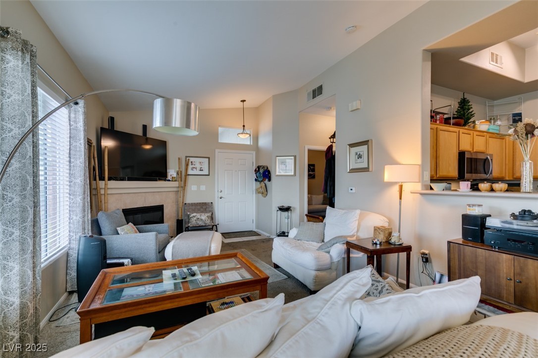 2305 West Horizon Ridge Parkway, Unit 2623 Henderson, NV 89052 - Photo 11 of 35 Carpeted living room featuring a tile fireplace and baseboards