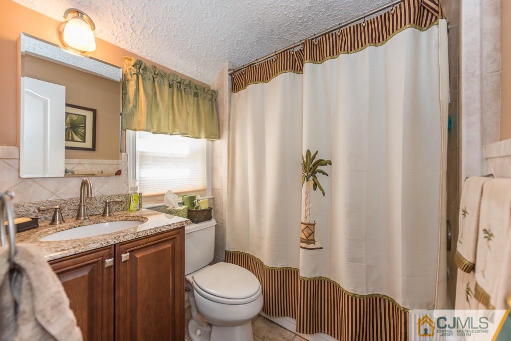 193 New Dover Road Colonia, NJ 07067 - Photo 19 of 25 a bathroom with a granite countertop sink and a mirror