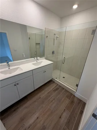 a bathroom with a double vanity sink toilet and shower