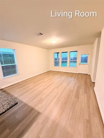 a view of a room with wooden floor and windows