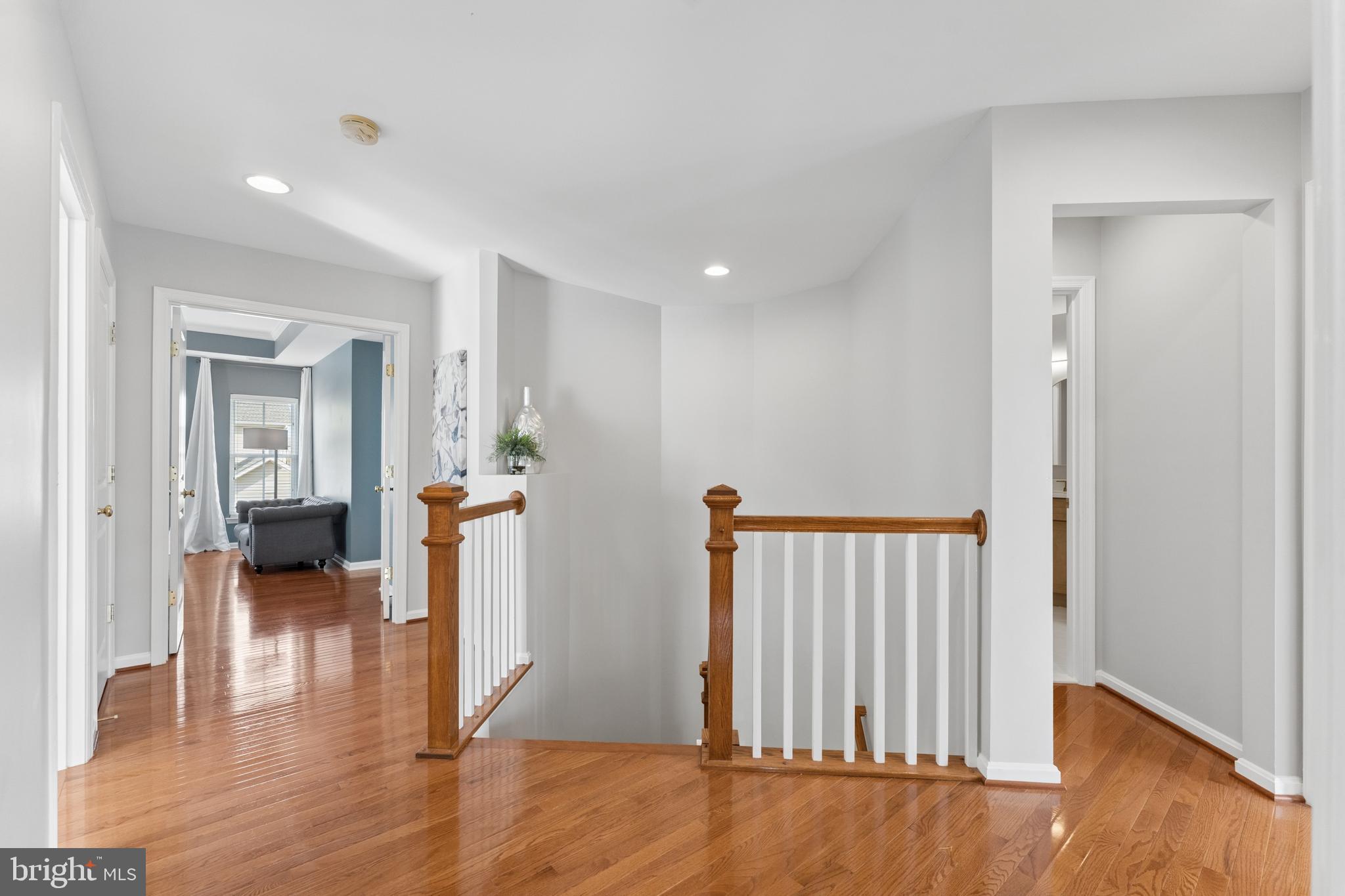 23342 Higbee Lane Brambleton, VA 20148 - Photo 31 of 73 a view of a hallway with wooden floor and a living room