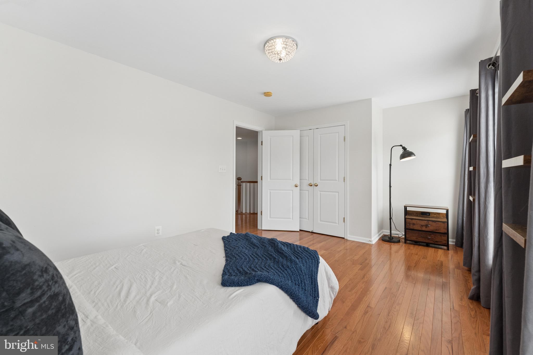 23342 Higbee Lane Brambleton, VA 20148 - Photo 42 of 73 a bedroom with a bed closet and a wooden floor