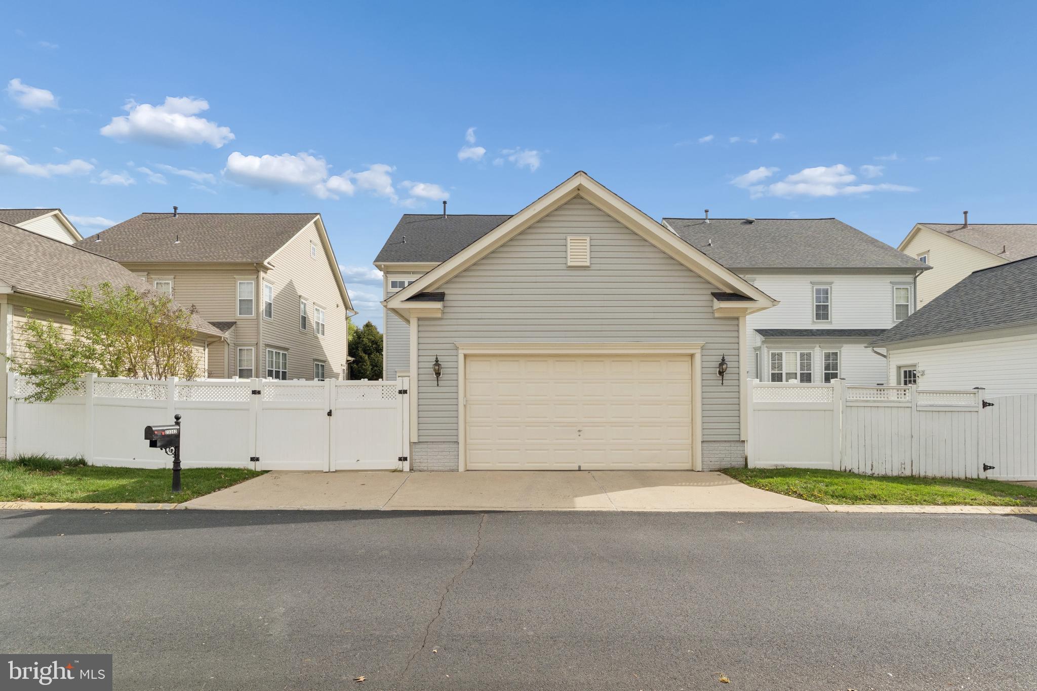 23342 Higbee Lane Brambleton, VA 20148 - Photo 68 of 73 a view of a white house with a yard and garage