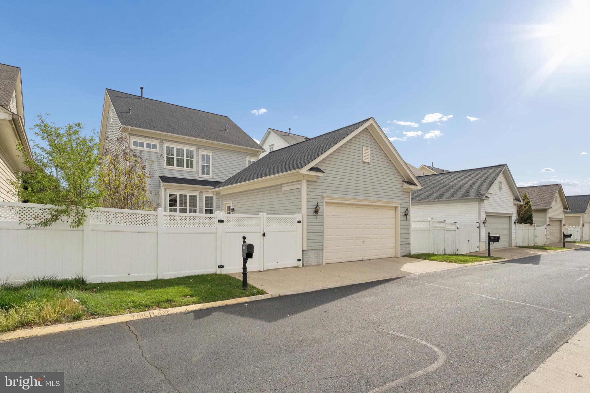 23342 Higbee Lane Brambleton, VA 20148 - Photo 69 of 73 a view of a white house with a yard and garage
