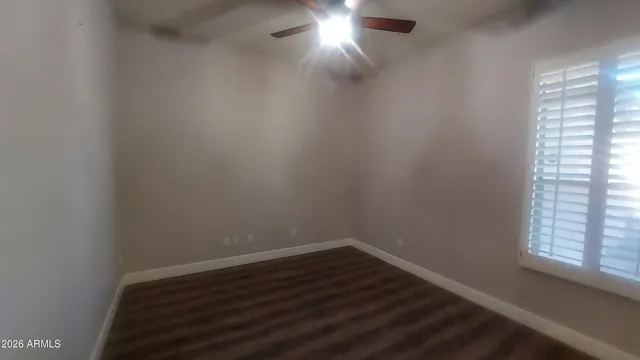a view of an empty room with wooden floor and a fireplace