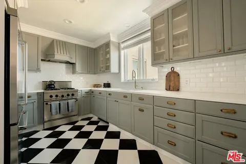 a kitchen with stainless steel appliances a stove a sink and a cabinets