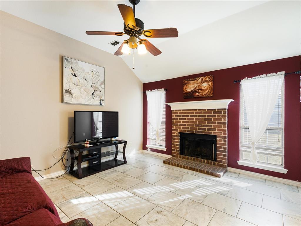 207 Quail Run Aubrey, TX 76227 - Photo 20 of 30 Living area with vaulted ceiling, a ceiling fan, a fireplace, and light tile patterned floors