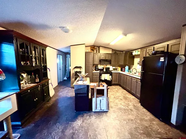 a living room with lots of furniture and refrigerator