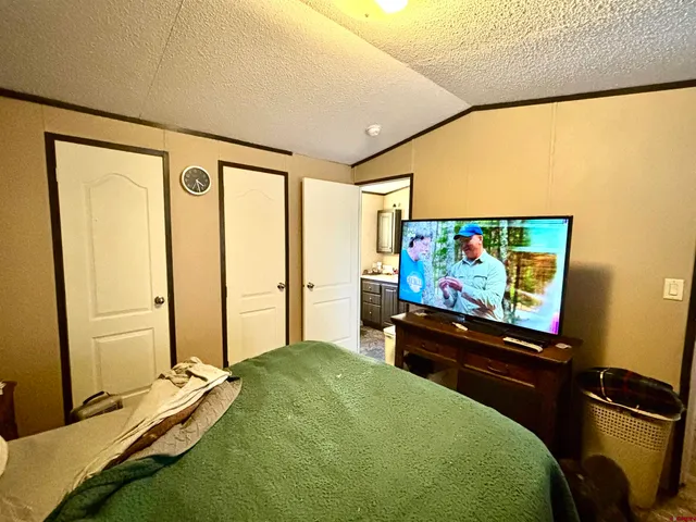 a bedroom with bed and a flat screen tv