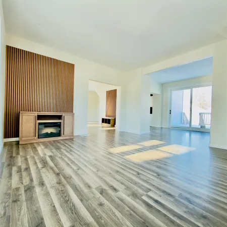 a view of empty room with wooden floor and fireplace