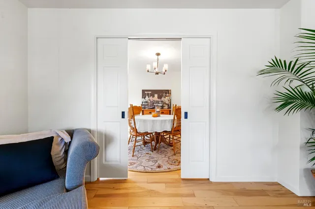 a dining room with furniture a chandelier and wooden floor