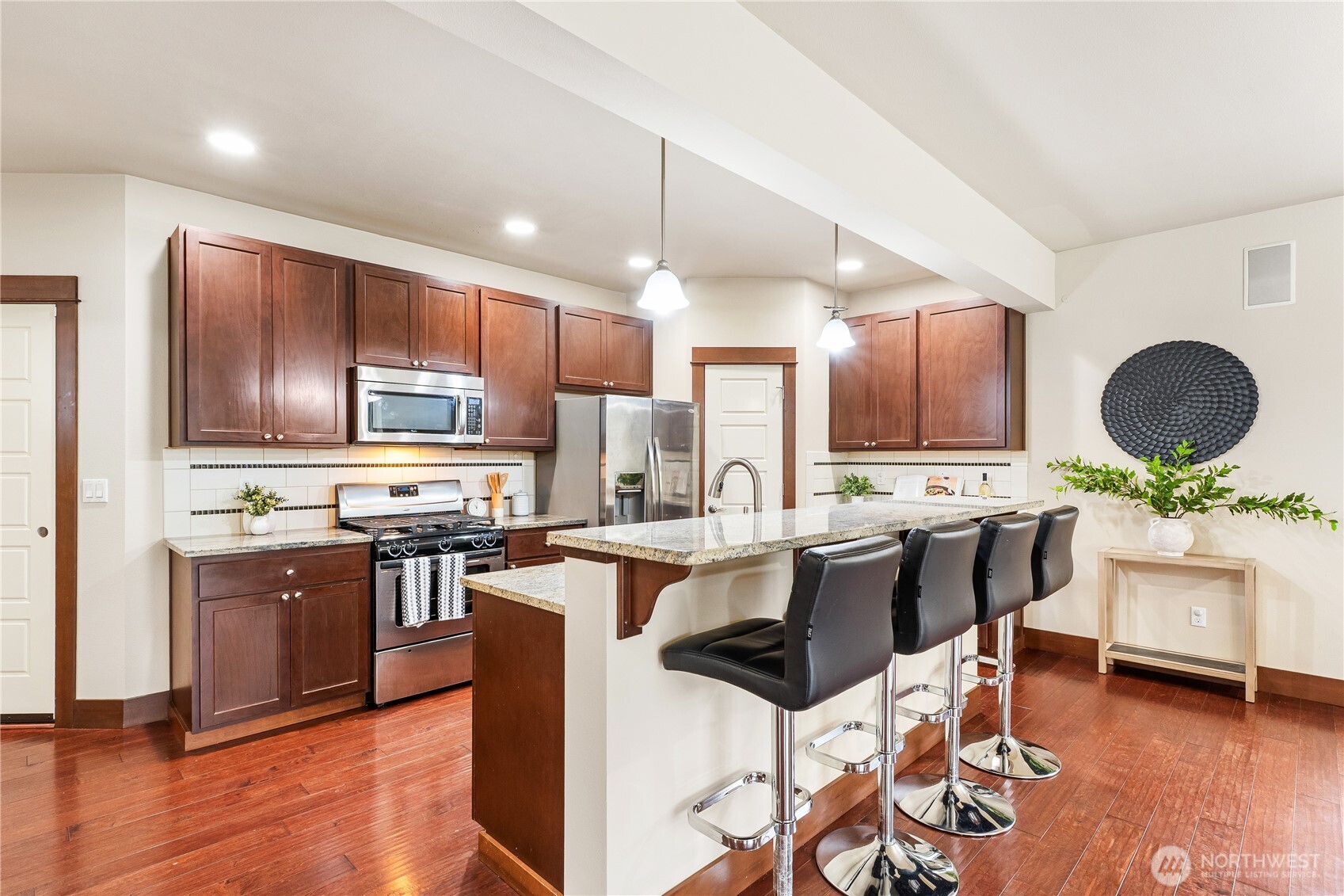 20304 3rd Drive Southeast Bothell, WA 98012 - Photo 10 of 31 a kitchen with kitchen island granite countertop wooden floors and stainless steel appliances