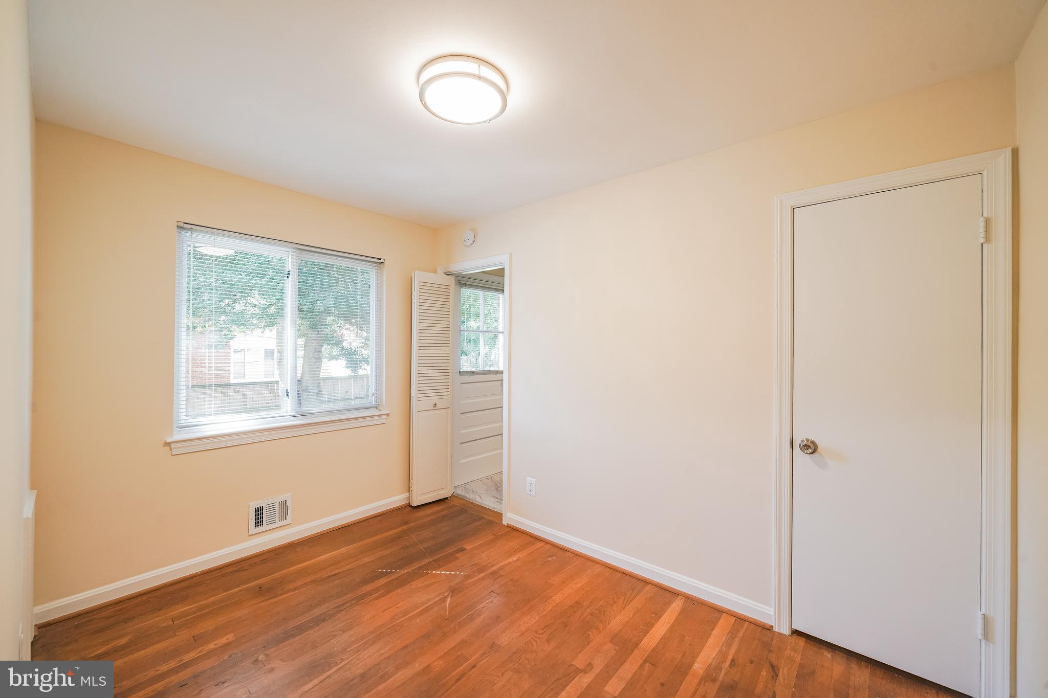 11500 Mapleview Drive Silver Spring, MD 20902 - Photo 15 of 32 a view of an empty room with wooden floor and a window