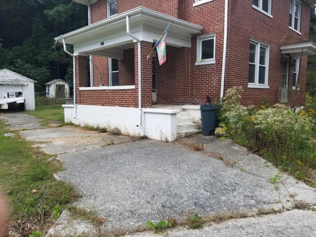5913 Brethren Road Roanoke, VA 24014 - Photo 4 of 17 a front view of a house with a yard and garage