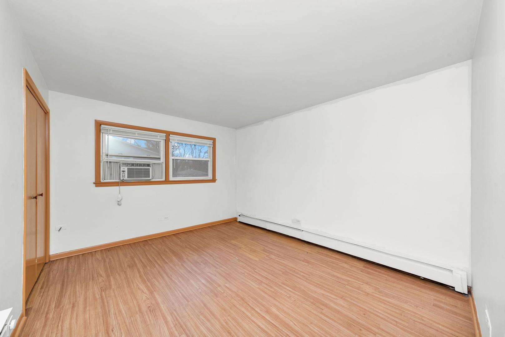 14526 Cottage Grove Avenue Dolton, IL 60419 - Photo 11 of 15 a view of an empty room with wooden floor and a window