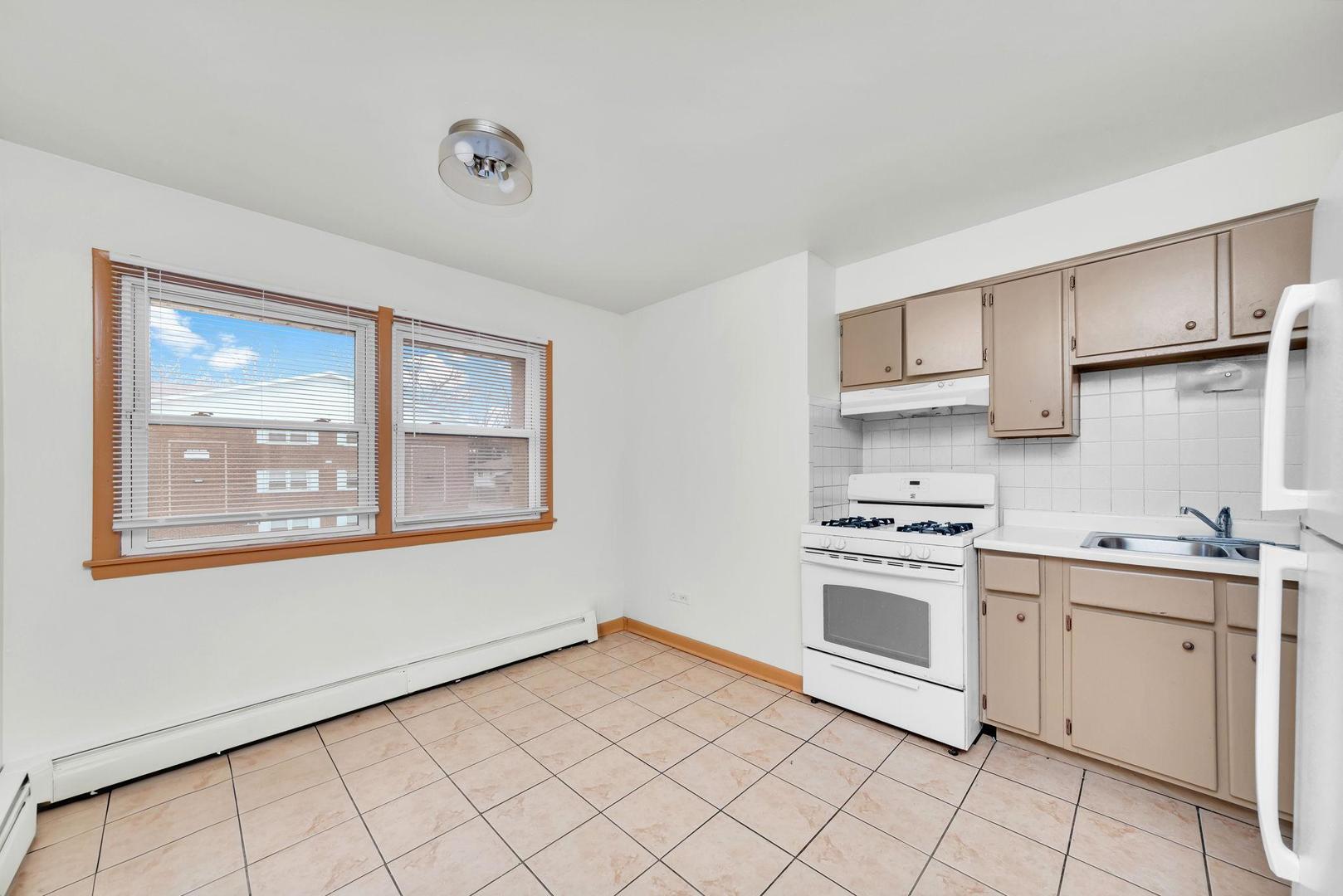 14526 Cottage Grove Avenue Dolton, IL 60419 - Photo 5 of 15 a kitchen with a stove a sink and a refrigerator