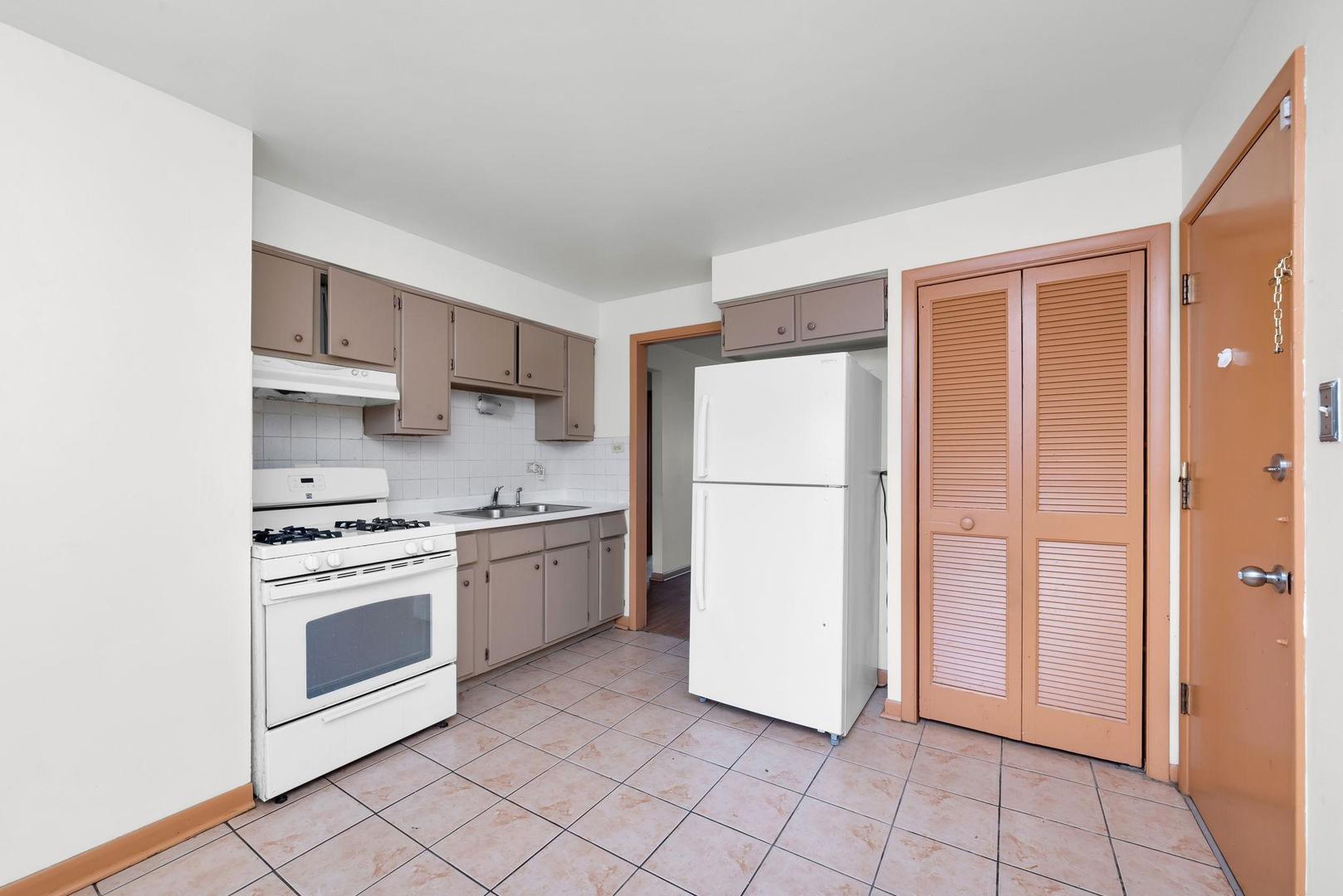 14526 Cottage Grove Avenue Dolton, IL 60419 - Photo 6 of 15 a kitchen with white cabinets and white appliances