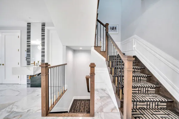 a view of staircase with lots of frames on wall and a window