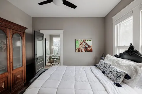 a bedroom with a large bed and a chandelier