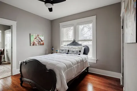 a bedroom with a bed and wooden floor