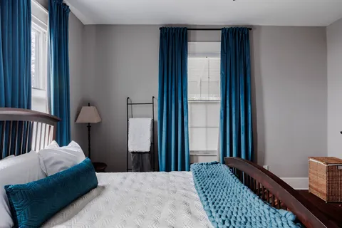 a bedroom with a bed lamp and a window