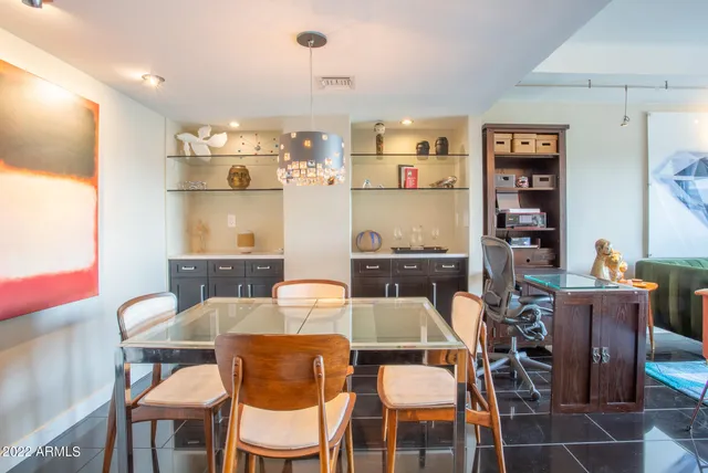 a bedroom with a bed and a lamp on the dresser