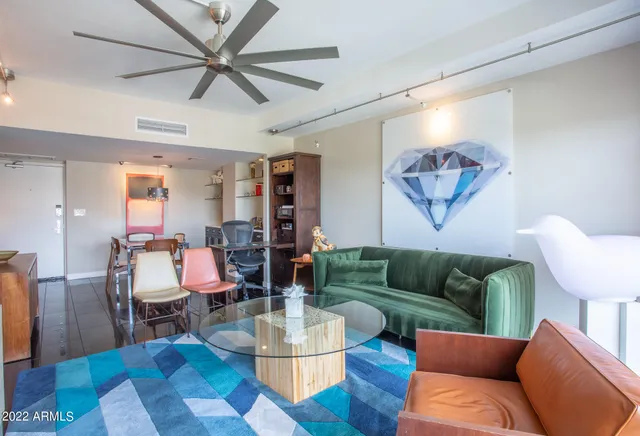 a living room with furniture a flat screen tv and a large window